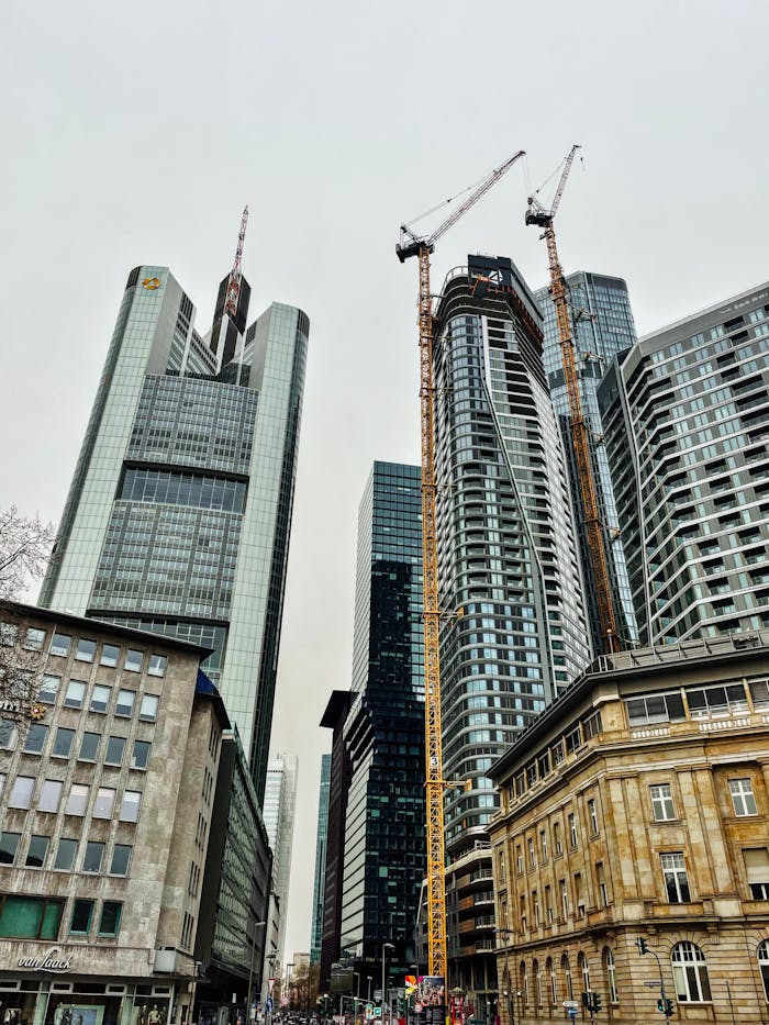 Modern skyscrapers and construction cranes in Frankfurt am Main's bustling cityscape.